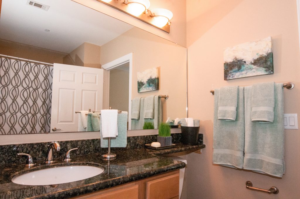 Southgate Apartments in Baton Rouge offers luxurious bathrooms featuring elegant granite countertops and a spacious mirror.