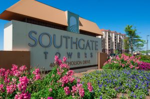 The sign for Southgate Towers is surrounded by flowers at Southgate Apartments in Baton Rouge.