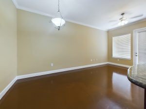 An empty room with brown floors and a ceiling fan available for Apartment Rentals.
