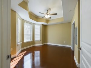 An empty room with hardwood floors and a ceiling fan available for Apartment Rentals.